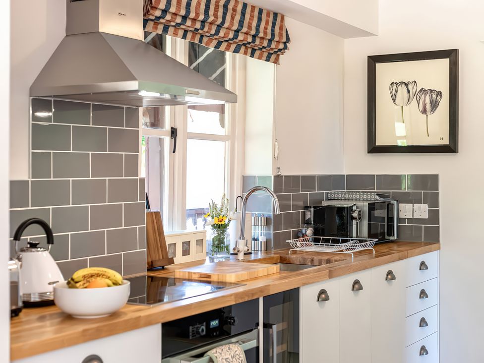 A kitchen with a sink and microwave at Dairy Cottage in Waddeston