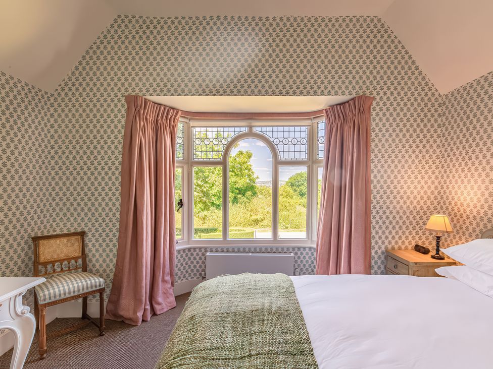 A bedroom with a bed and window at Dairy Cottage in Waddeston