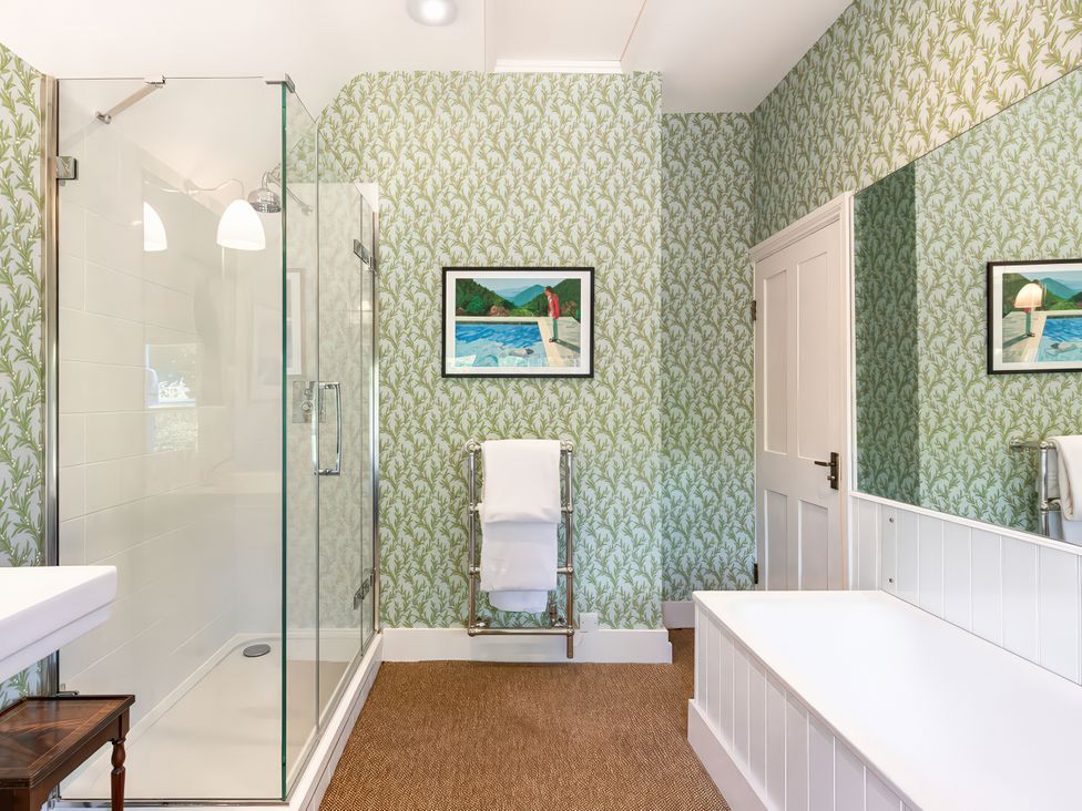 A bathroom with a shower and towel rack at Dairy Cottage in Waddeston