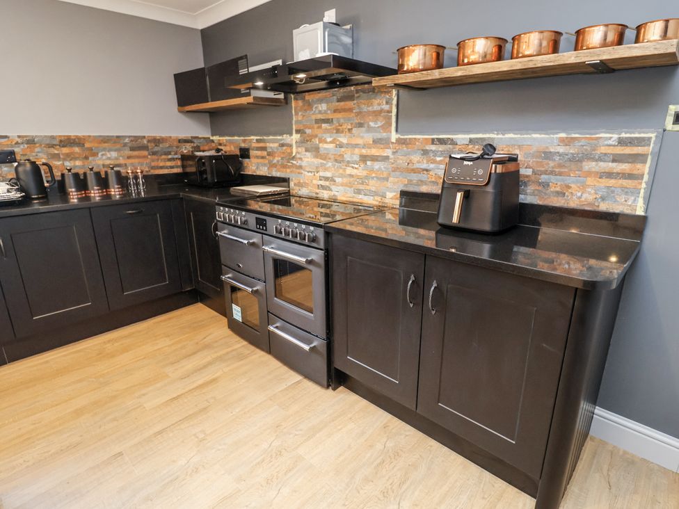 A kitchen with an oven and countertop appliances at Holly Farm in Colchester