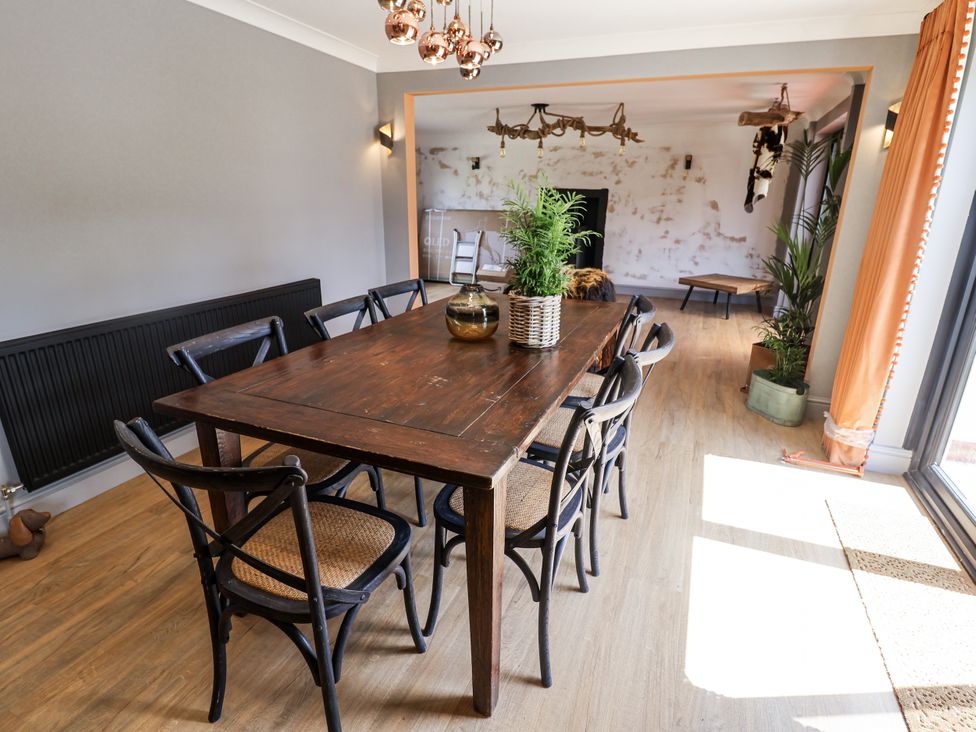 A dining room with a table and chairs at Holly Farm in Colchester