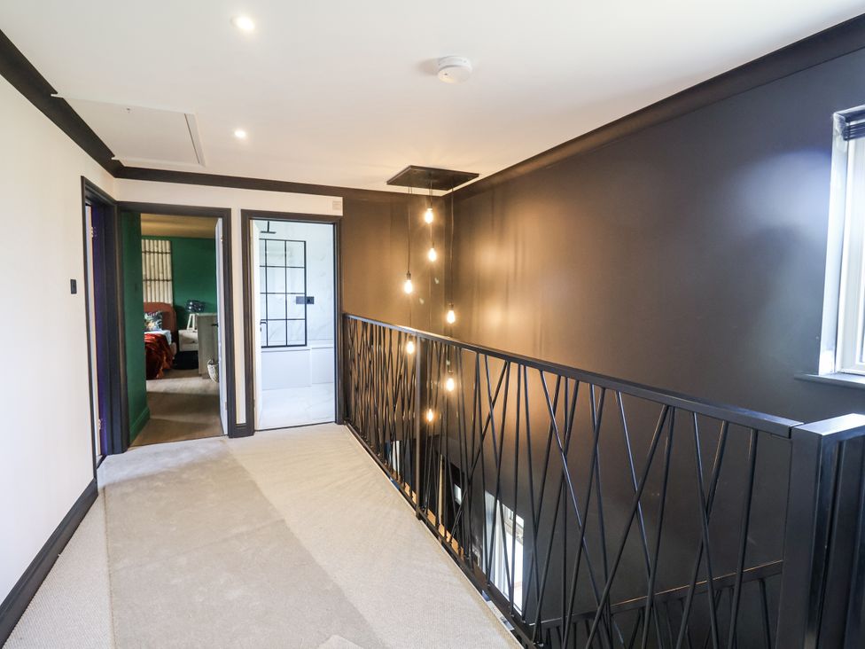 A hallway with lights and doors at Holly Farm in Colchester