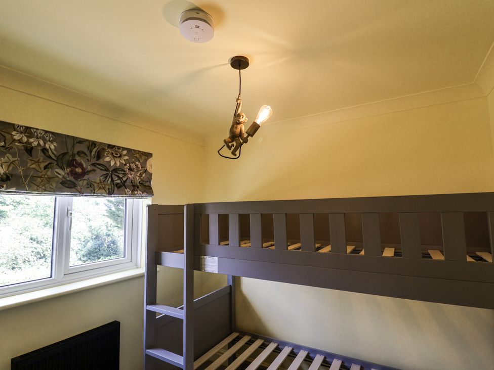 A bedroom with a bunk bed and window at Holly Farm in Colchester