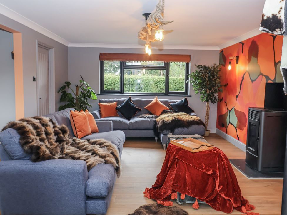 A living room with a blue sofa and a coffee table at Holly Farm in Brantham