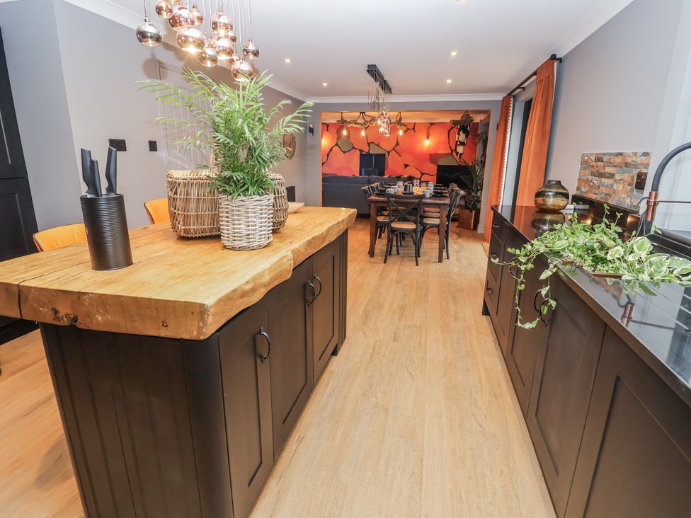 A kitchen with a wooden island and dining area at Holly Farm in Brantham