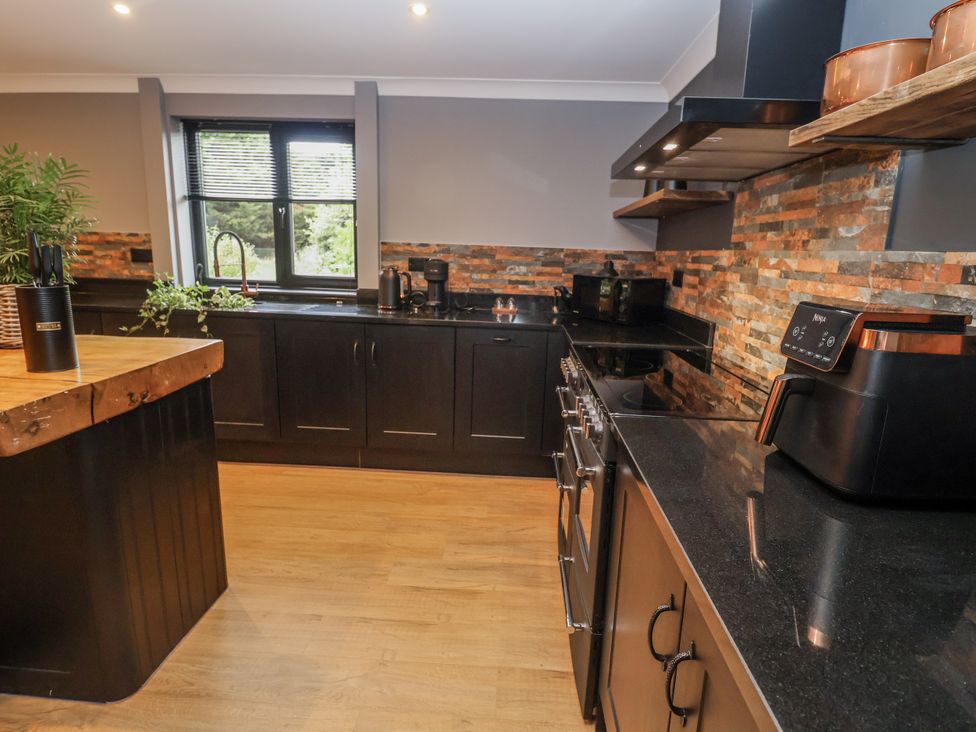 A kitchen with appliances and a window at Holly Farm in Brantham