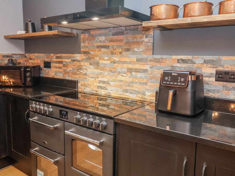 A kitchen with an oven, air fryer, and microwave at Holly Farm in Brantham