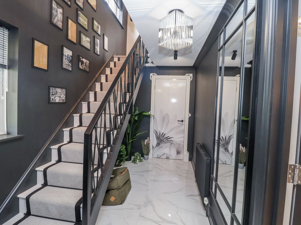 A hallway with a staircase and wall decor at Holly Farm in Brantham