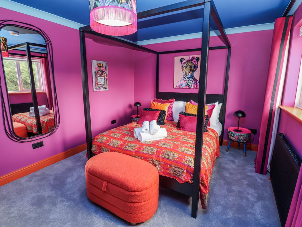 A bedroom with a four-poster bed and a mirror at Holly Farm in Brantham