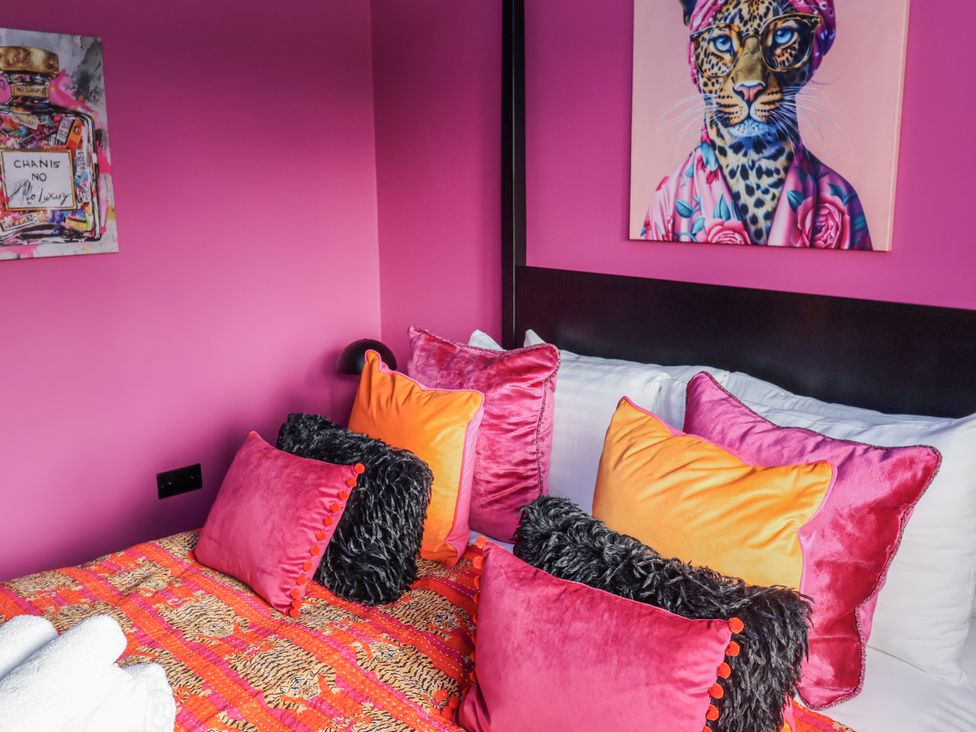 A bed with colorful pillows in a bedroom at Holly Farm in Brantham