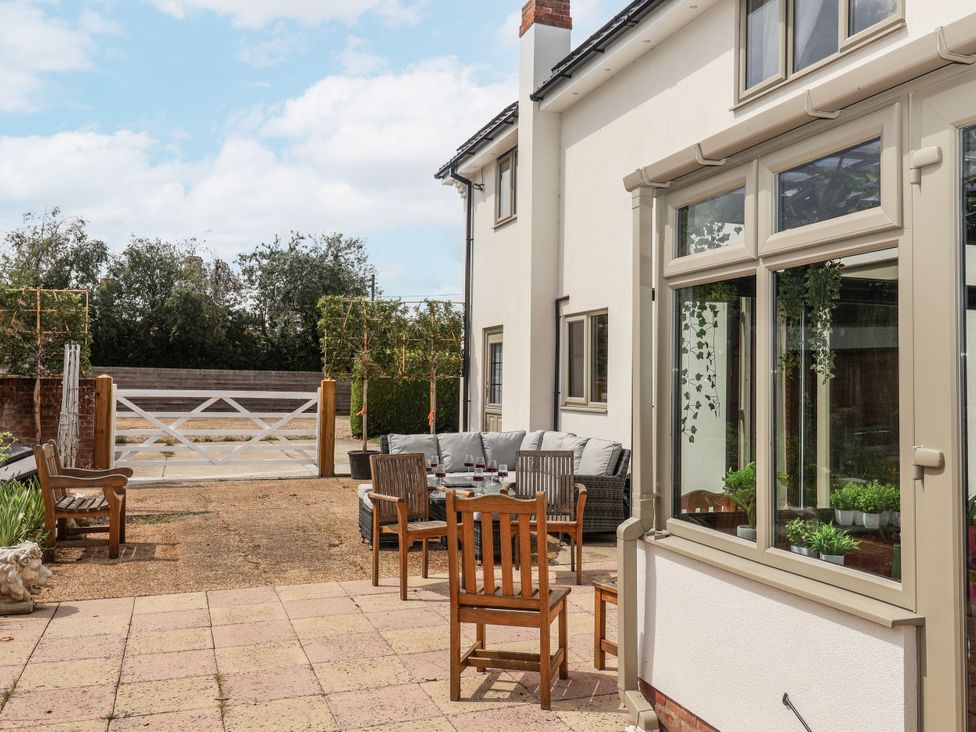 An outdoor seating area with a table and chairs at Holly Farm in Brantham