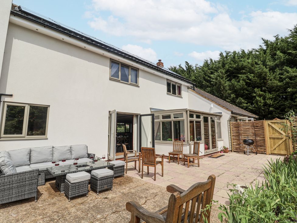 A garden with outdoor furniture and a grill at Holly Farm in Brantham