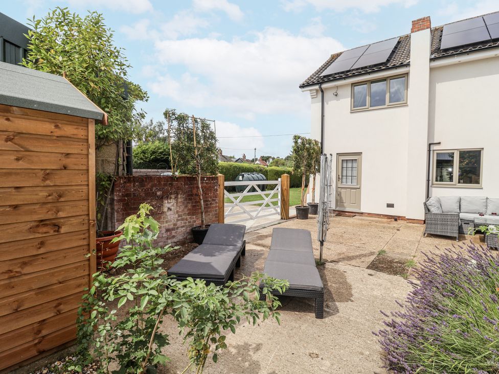 An outdoor area with lounge chairs and a shed at Holly Farm in Brantham