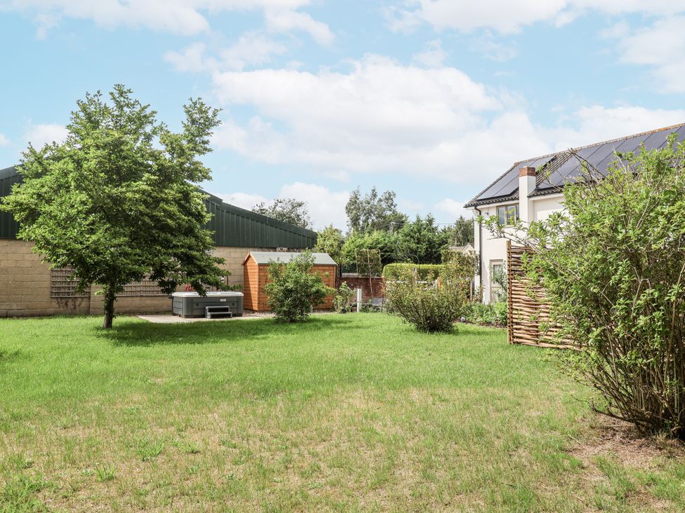 A garden with a tree and shed at Holly Farm in Brantham