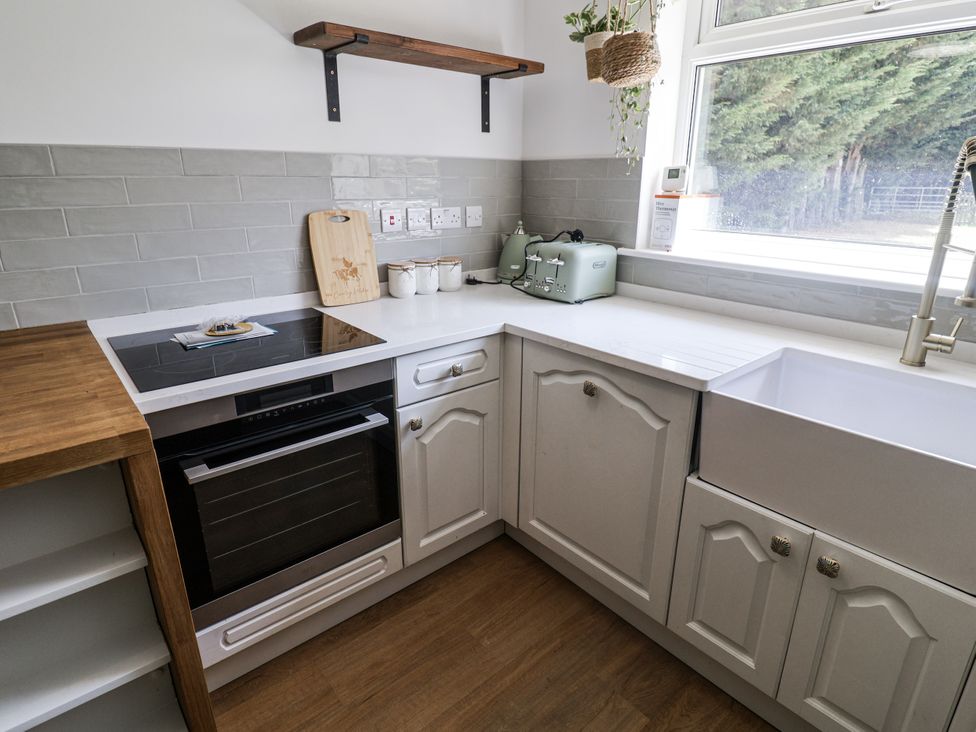 A kitchen with a stove, sink, and toaster at Annexe in Colchester