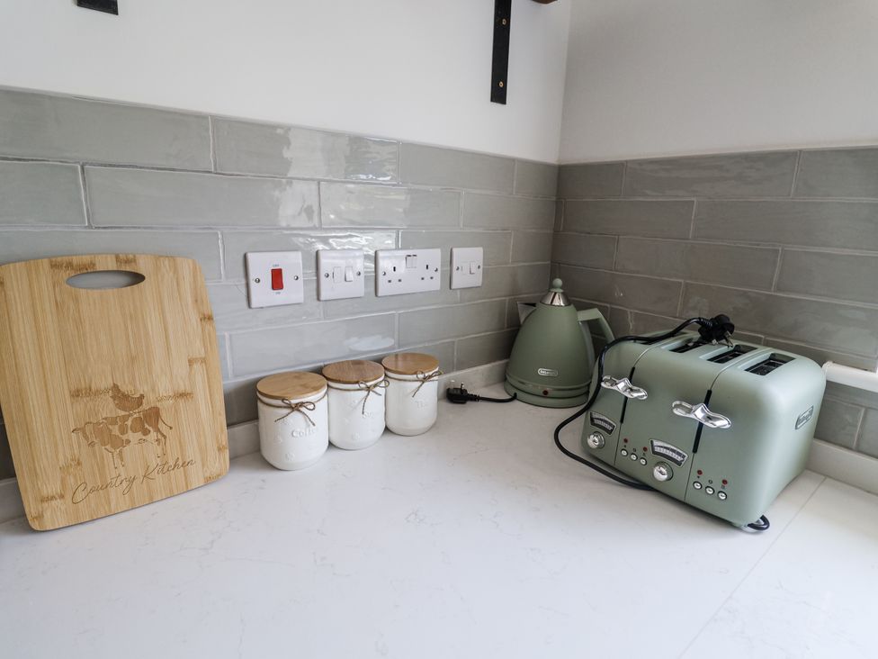 A kitchen counter with a toaster, kettle, and storage jars at Annexe in Colchester