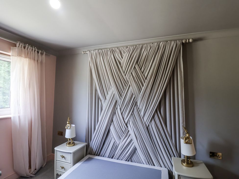A bedroom with curtains and a bed at Annexe in Colchester