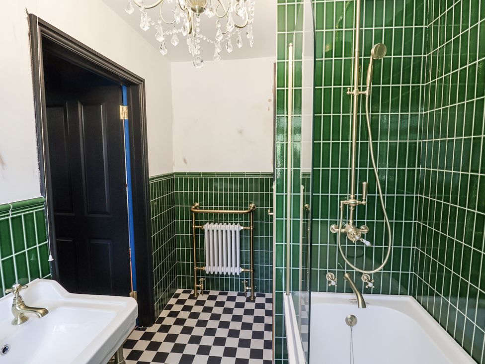 A bathroom with a bathtub and shower in Annexe Colchester