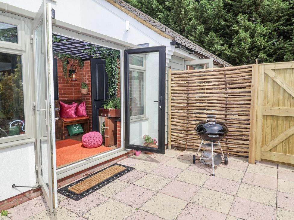 An outdoor patio with a grill and furniture at Annexe East End near Brantham