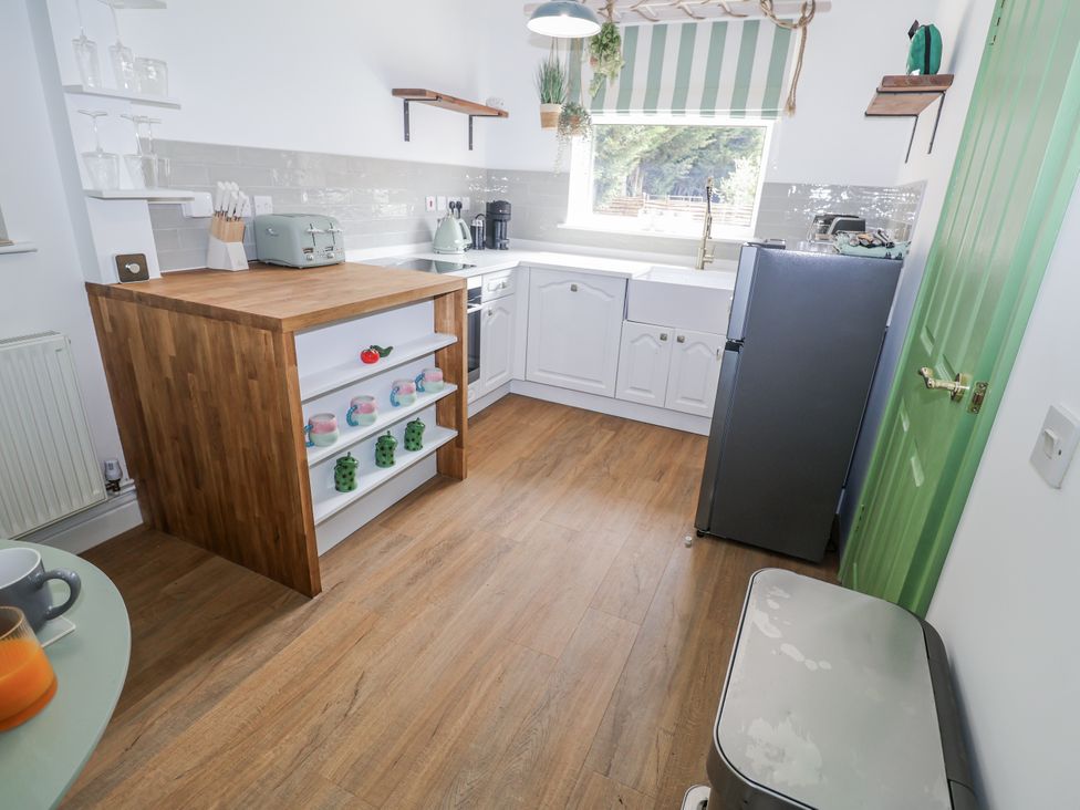 A kitchen with a table and stools at Annexe East End near Brantham