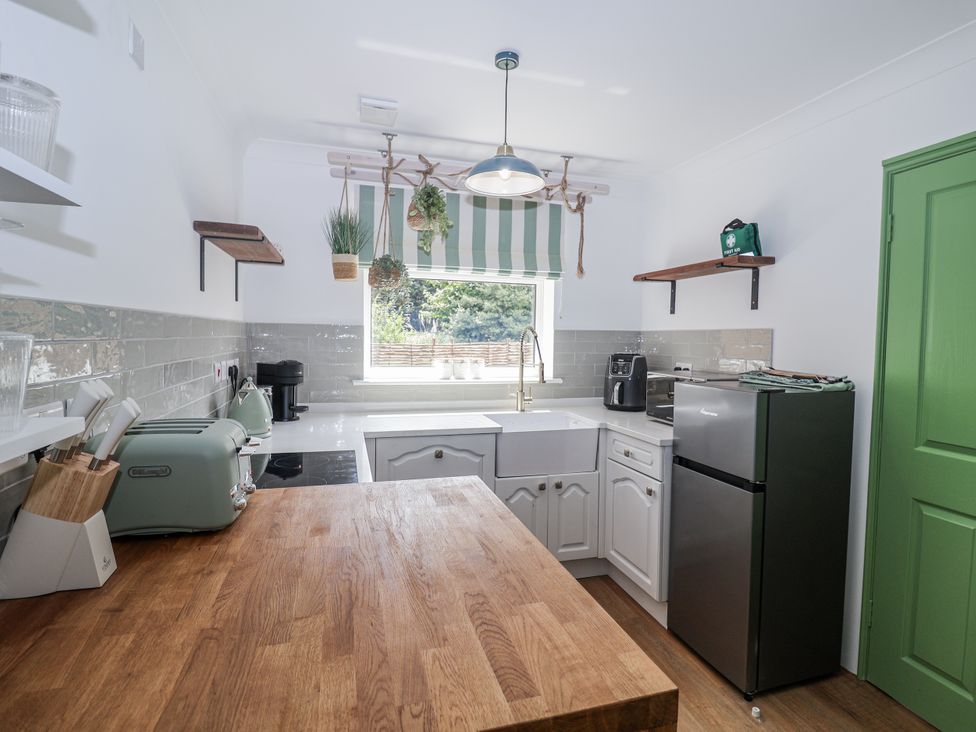 A kitchen with a sink, fridge, and countertop at Annexe East End near Brantham