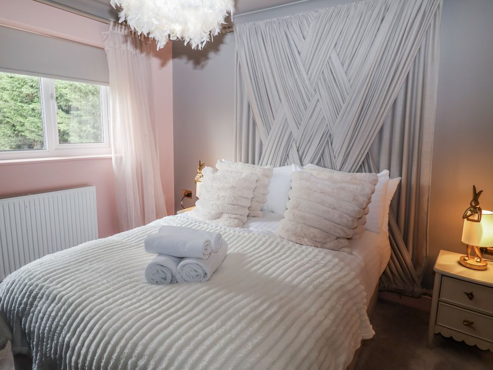 A bedroom with a bed and decorative cushions at Annexe, East End near Brantham