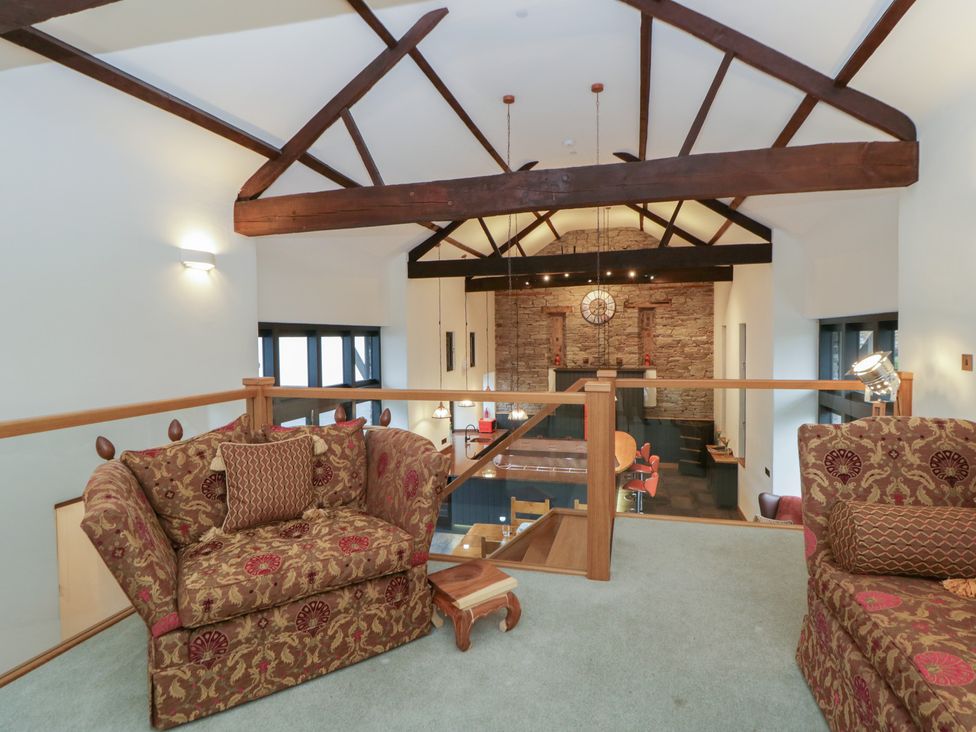 A living room with armchairs and a dining area at The Barn at Sunny Barn in Brecon