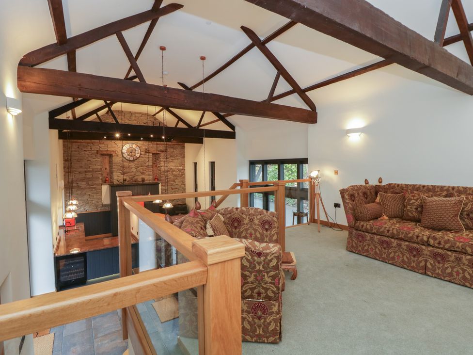 A living room with sofas and a wall clock at The Barn at Sunny Barn Brecon