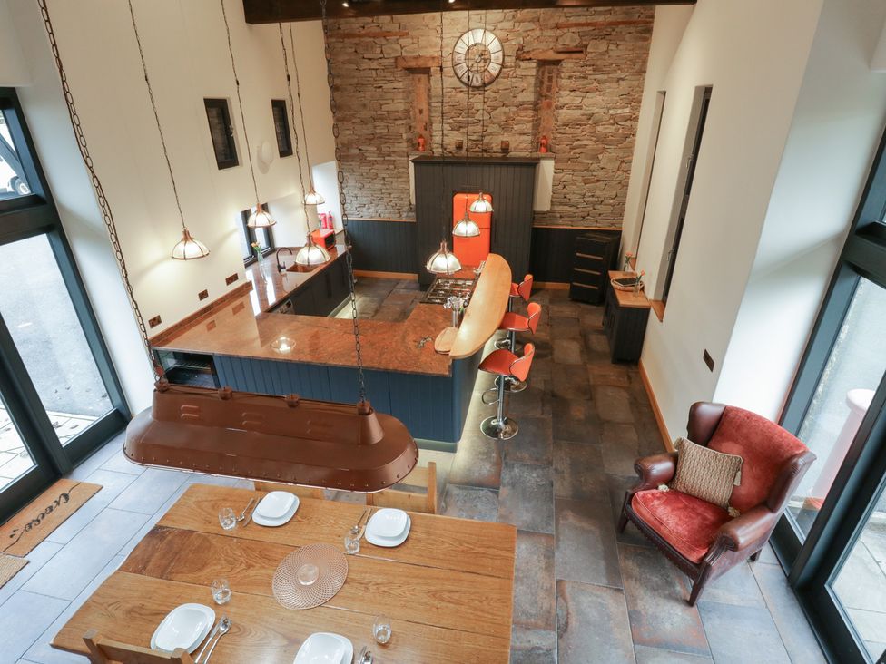 A kitchen with bar stools and a dining table at The Barn at Sunny Barn in Brecon