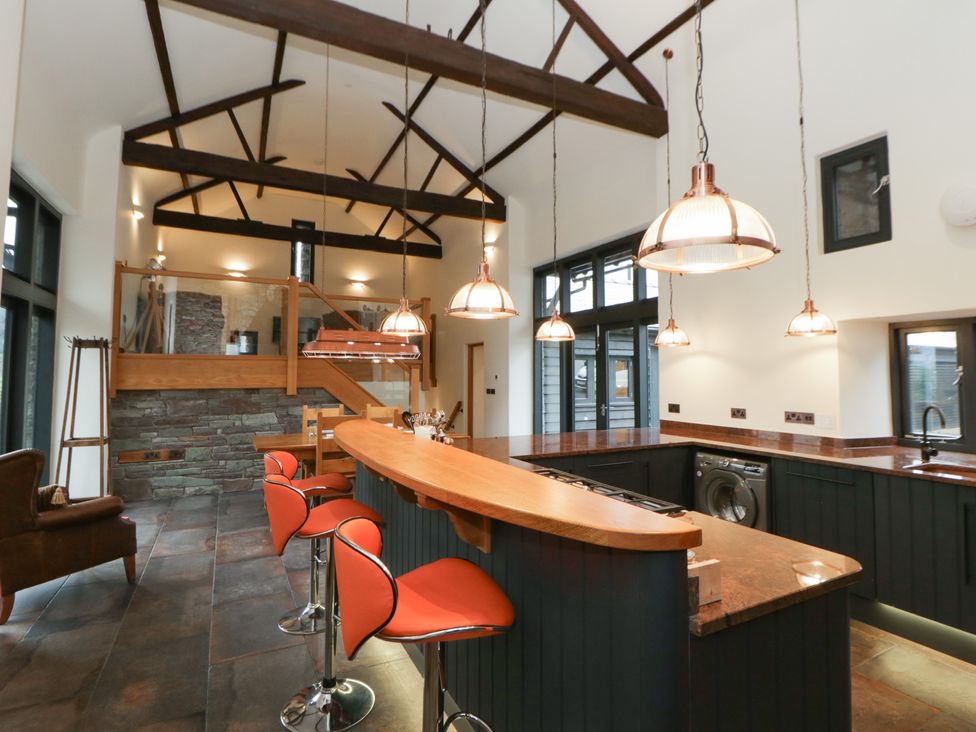 A kitchen with a bar and stools at The Barn at Sunny Barn in Brecon