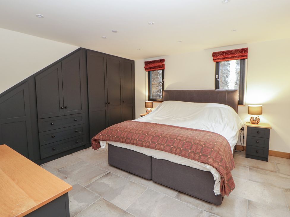 A bedroom with a bed and wardrobe at The Barn at Sunny Barn in Brecon