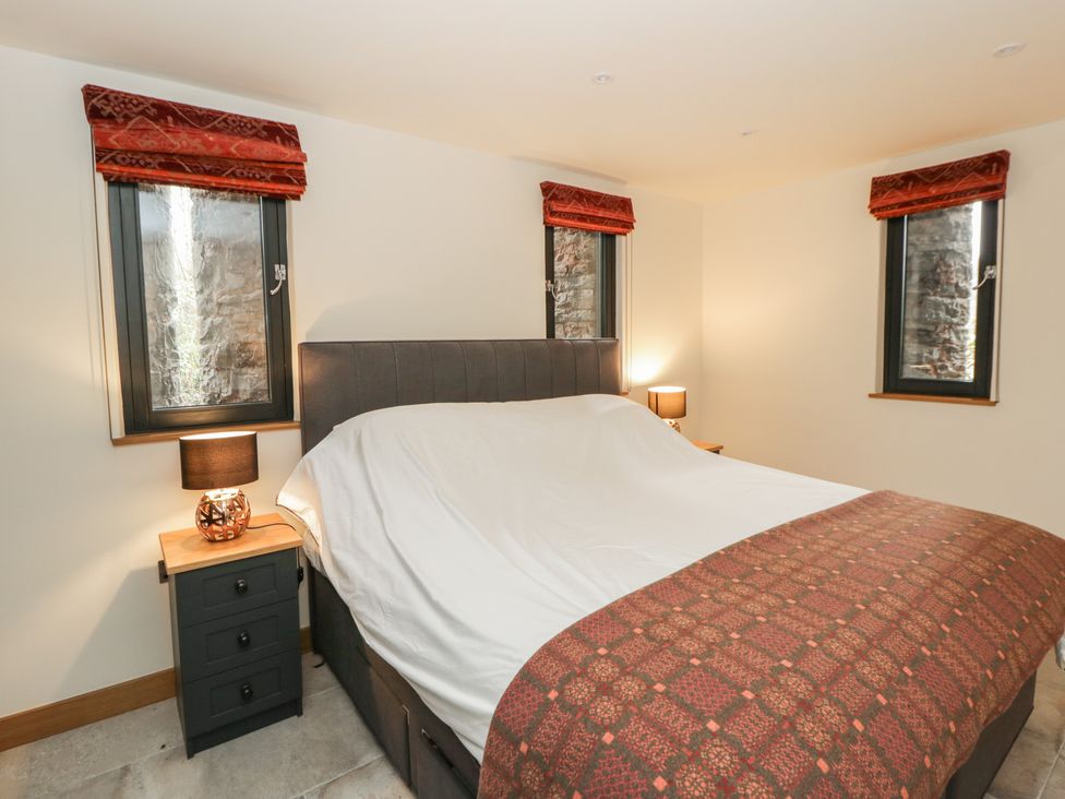 A bedroom with a bed and bedside tables at The Barn at Sunny Barn in Brecon