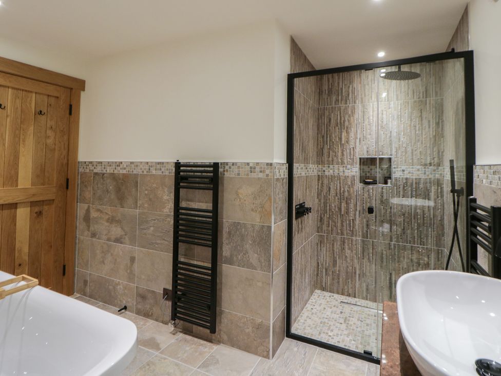 A bathroom with a shower and bathtub at The Barn at Sunny Barn Brecon