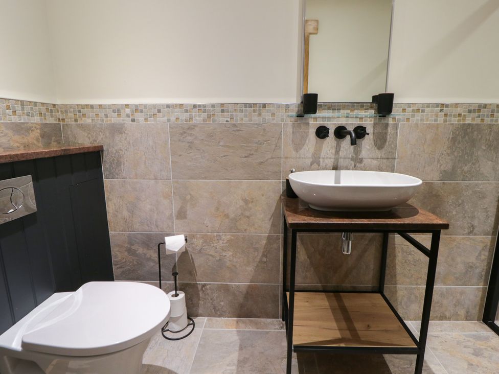 A bathroom with a toilet and a wash basin at The Barn at Sunny Barn Brecon