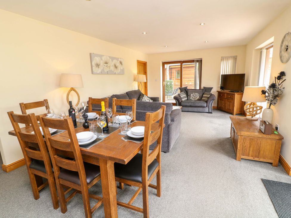 A dining room with a table and chairs at Sunnyside Lodge, Thorpe-On-The-Hill