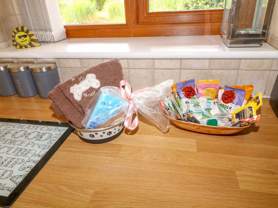 A kitchen counter with a dog bowl, towels and a basket of treats at Sunnyside Lodge in Thorpe-On-The-Hill