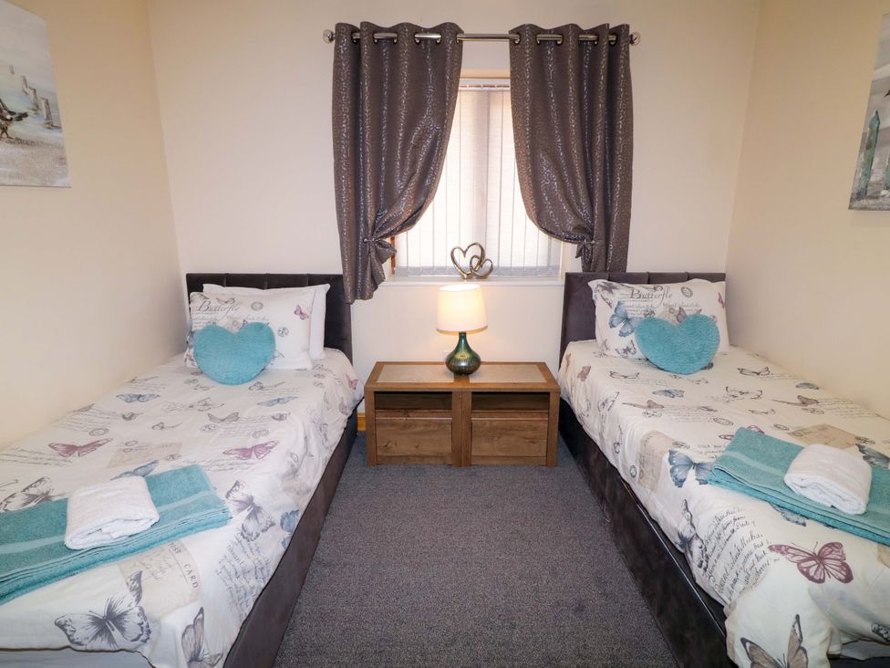 A bedroom with two beds and a lamp at Sunnyside Lodge in Thorpe-On-The-Hill