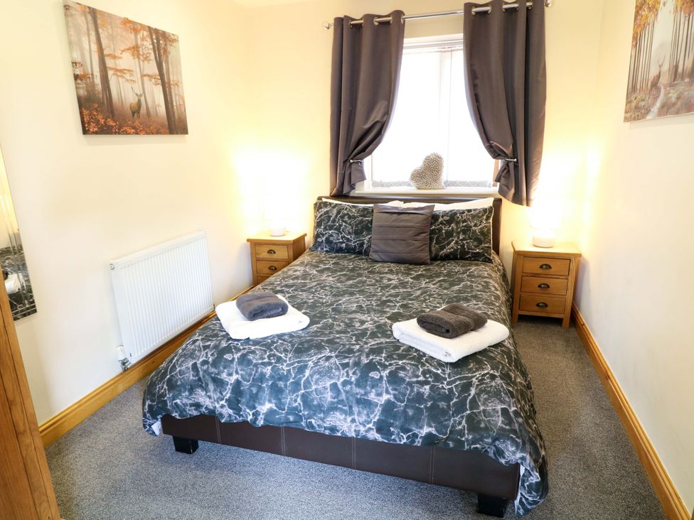 A bedroom with a bed and bedside tables at Sunnyside Lodge in Thorpe-On-The-Hill