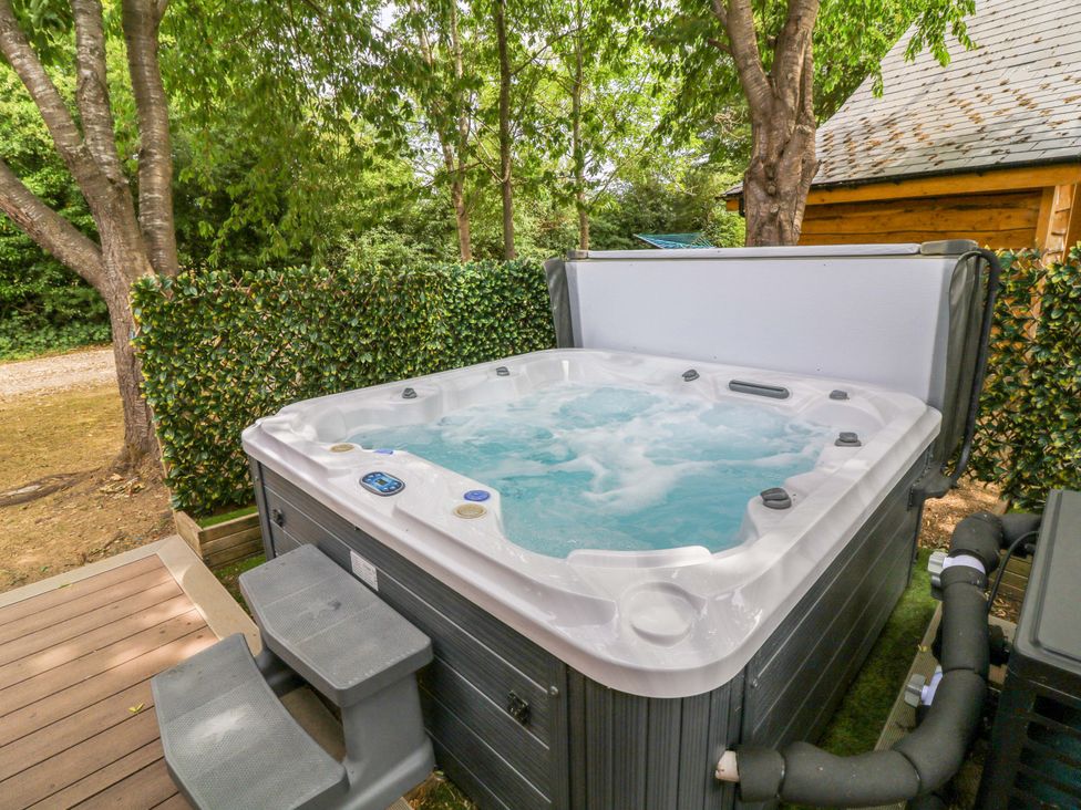 A hot tub with steps and pump in an outdoor area at Sunnyside Lodge in Thorpe-On-The-Hill