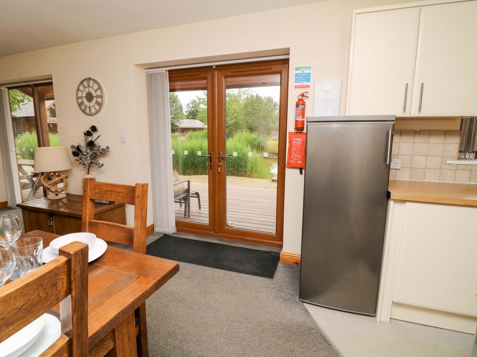 A kitchen with a dining table and chairs at Sunnyside Lodge in Thorpe-On-The-Hill