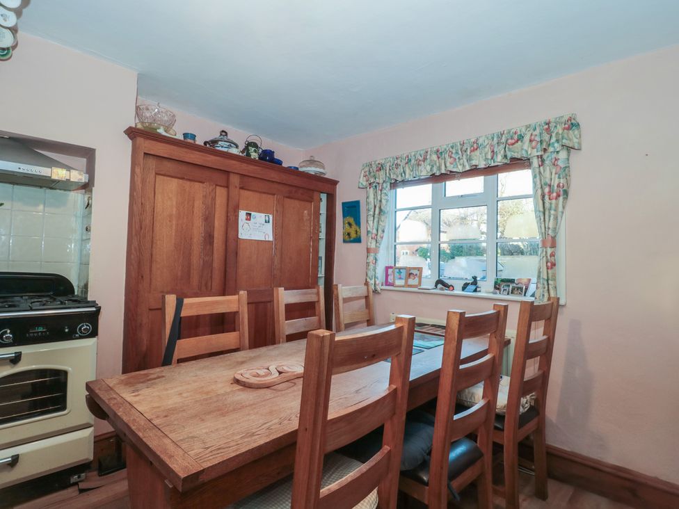 A kitchen with a dining table and chairs at Vine Cottage in Alderton