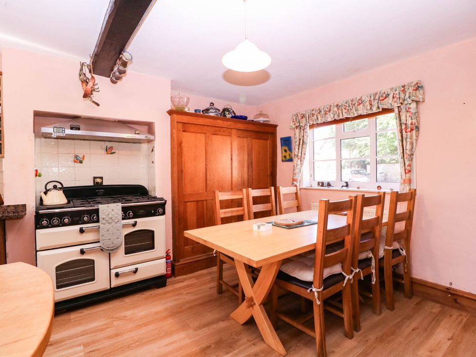 A kitchen with a table and chairs at Vine Cottage in Cheltenham