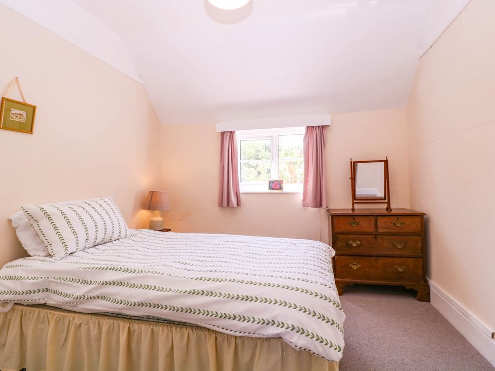 A bedroom with a bed and a chest of drawers at Vine Cottage in Cheltenham