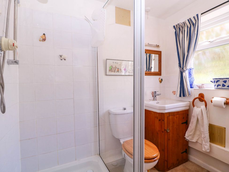 A bathroom with a shower, toilet, and sink at Vine Cottage in Cheltenham