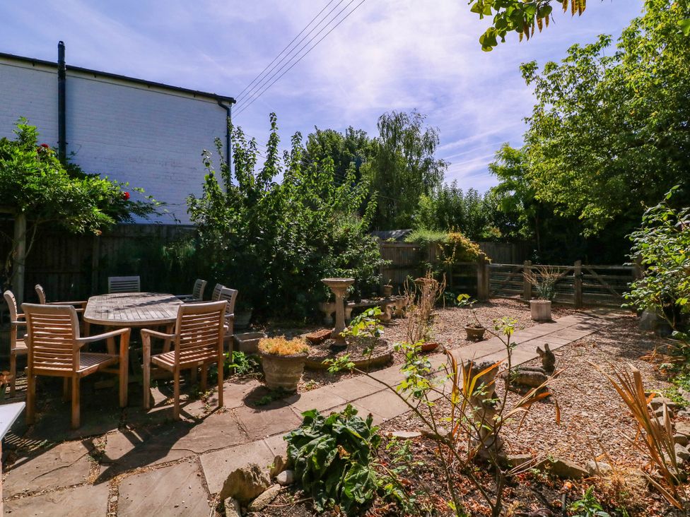 A garden with seating and plants at Vine Cottage in Cheltenham