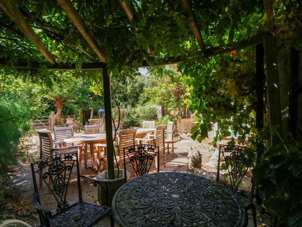 A garden with tables and chairs at Vine Cottage in Cheltenham