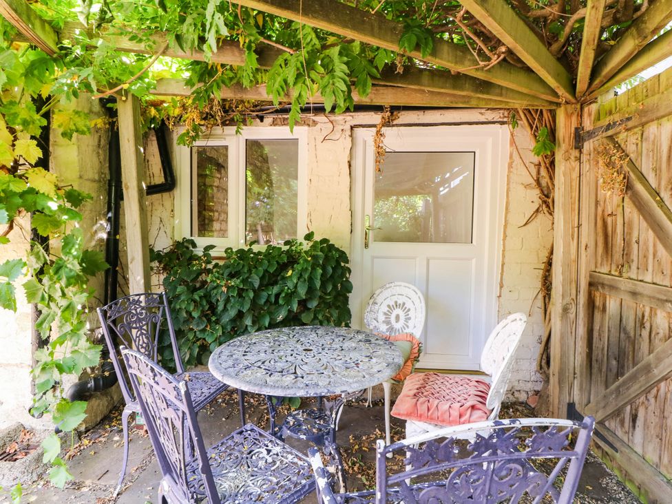 A garden area with a table and chairs at Vine Cottage in Cheltenham
