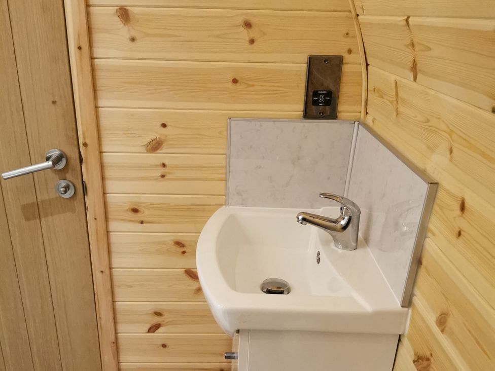 A bathroom with a sink and door at Lodge 2 Pontyates