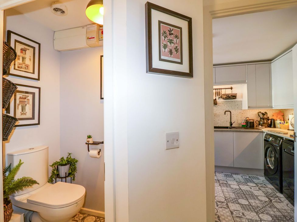 A bathroom with a toilet and wall art at 21 Olympic Way Plymouth