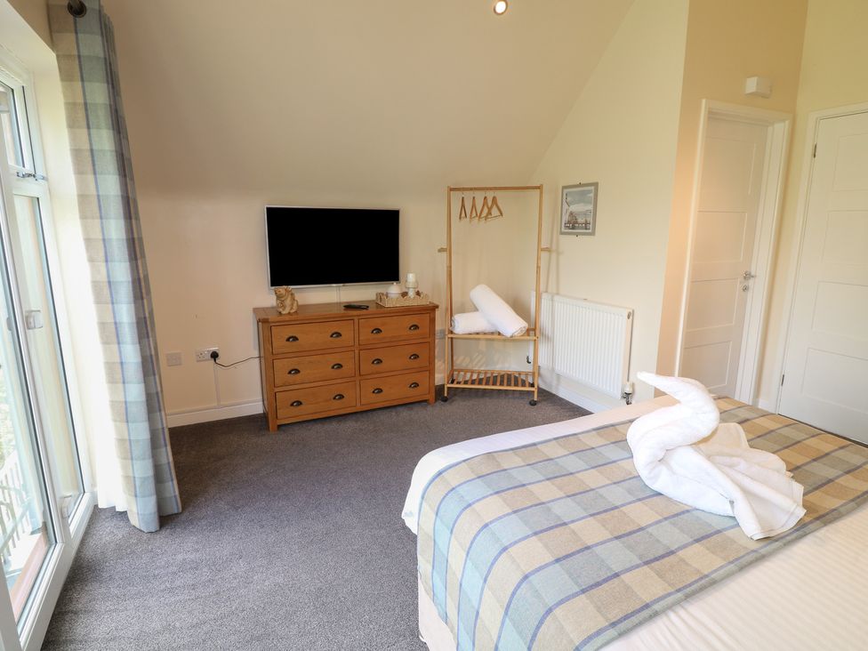 A bedroom with a television and dresser at James Ville Marina Lodge 10 in Brigg